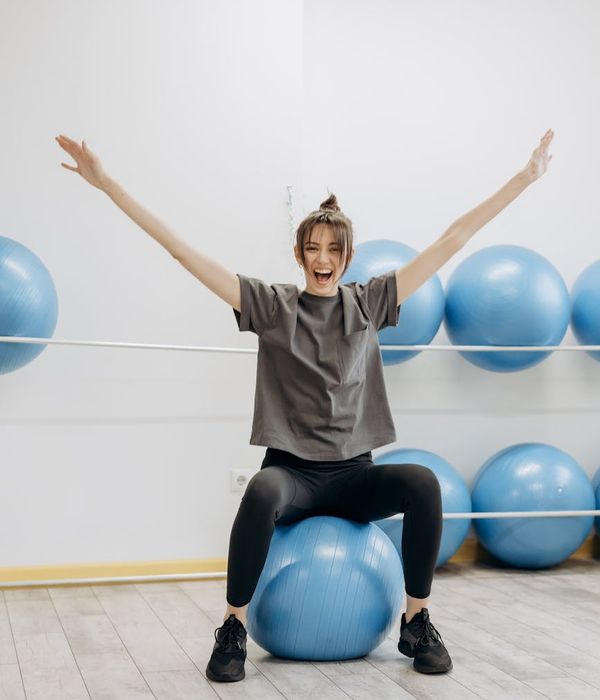 Woman feeling energetic and happy after a light cardio workout in a modern living room.